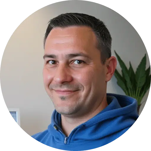 Person in blauem Kapuzenpullover vor unscharfem Hintergrund mit Pflanze.